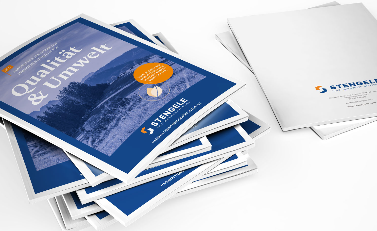 Stengele Printprodukte Zwei Stapel mit Broschüren von Stengele Holz- und Kunststofftechnik.