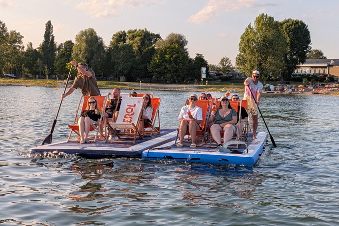 Das AB3-Team sitzt bei seinem Ausflug auf zwei schwimmenden SUP-Plattformen auf dem Bodensee.