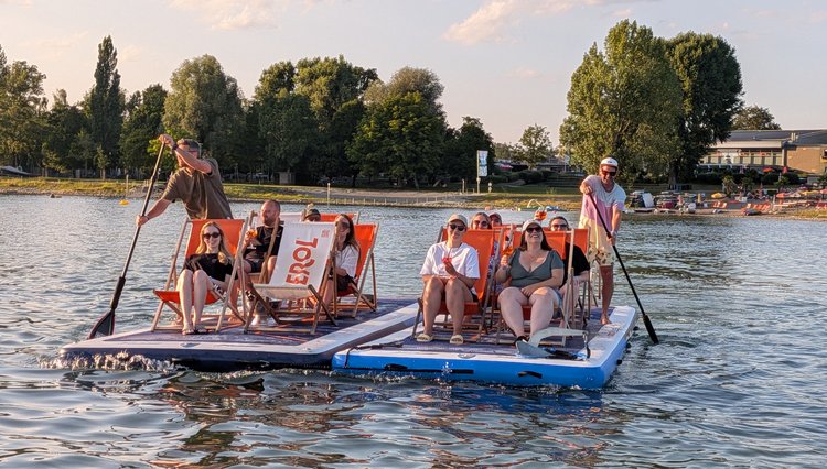 Das AB3-Team sitzt bei seinem Ausflug auf zwei schwimmenden SUP-Plattformen auf dem Bodensee.