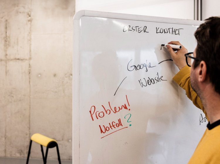 Person sammelt Ideen am Whiteboard