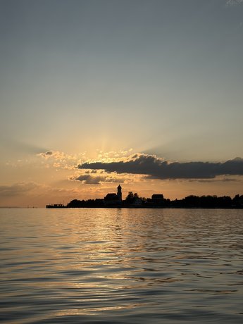 Die untergehende Sonne taucht Wasserburg und den Bodensee in goldenes Abendlicht.