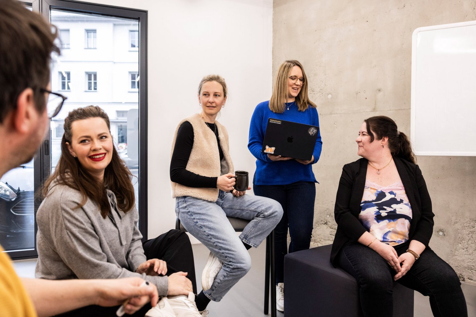 Fünf Mitarbeitende der Alpenblickdrei Werbeagentur posieren gemeinsam beim Brainstorming