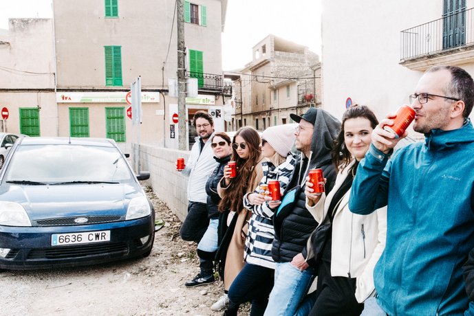 Coole Gang von AB3 Mitarbeitern an Mauer in Binissalem auf Mallorca mit Auto im Hintergrund