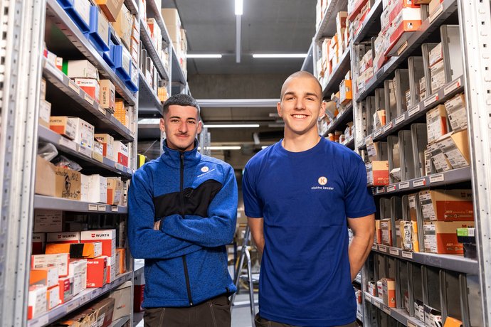 Zwei Mitarbeiter von Elektro Kessler stehen im Lager zwischen Regalen