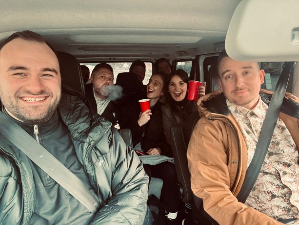 Team lächelt in die Kamera bei einer gemeinsamen Autofahrt